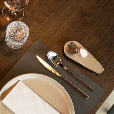 TOWELLO Oasis Curve serving bowl on wooden table with spoon, knife, glass, and plate set for dining.